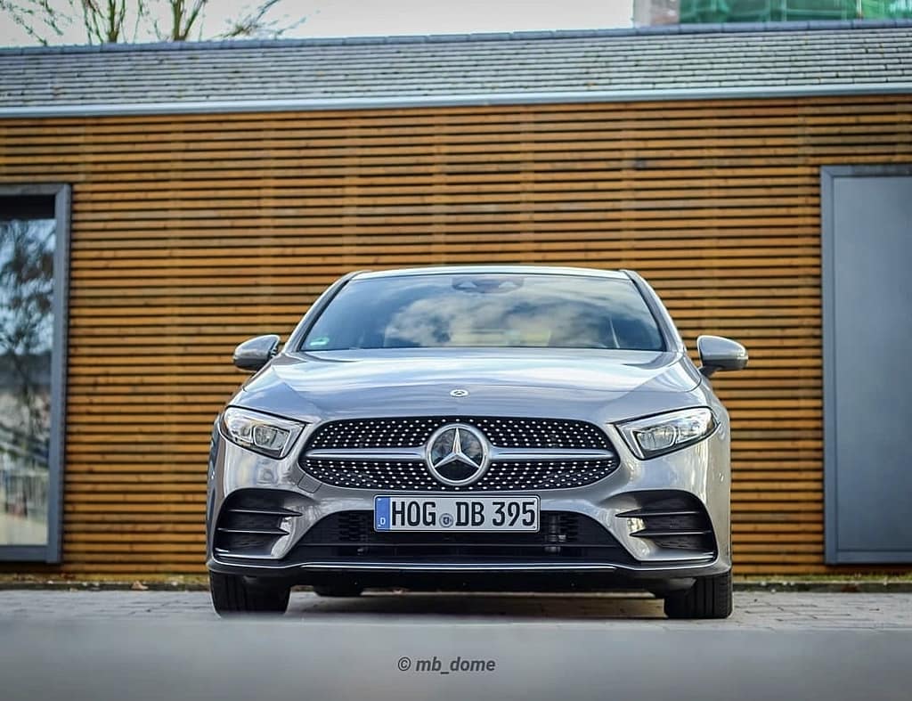 Mercedes-Benz A-Klasse W177 in Silber vor moderner Holzfassade mit Front- und Seitenansicht