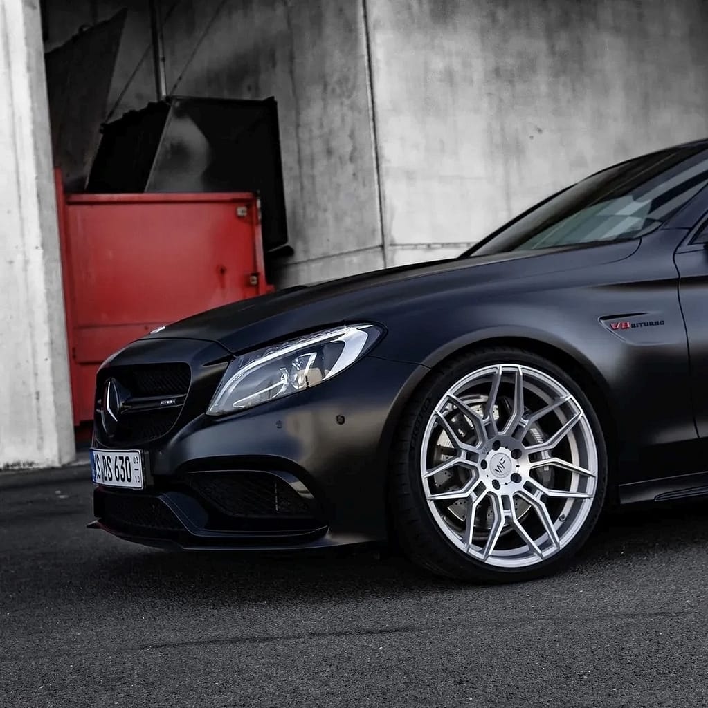 Mercedes-AMG C63 W205 in mattschwarz mit V8 Biturbo Motor in urbaner Industrieumgebung bei nasser Straße fotografiert