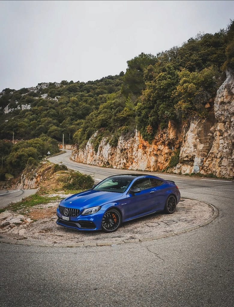 Mercedes-AMG C63 S Coupé in Blau mit Blick über Monaco und mediterrane Landschaft