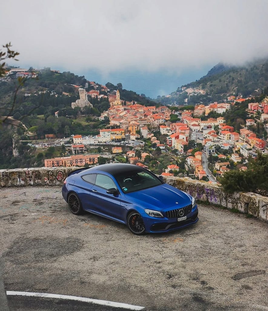 Blauer Mercedes-AMG C63 S Coupé C205 auf einer kurvigen Küstenstraße an der französischen Riviera