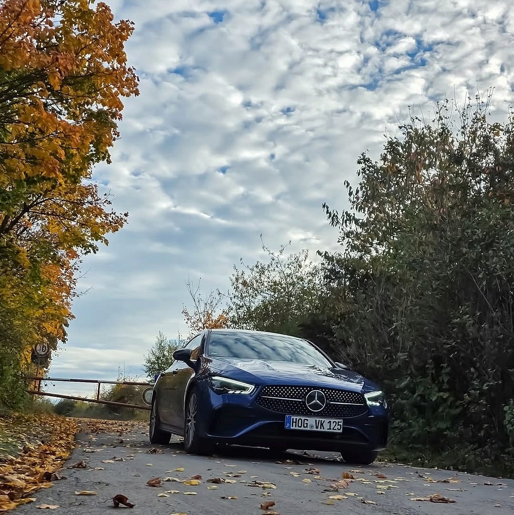 Mercedes Benz CLA Shooting Brake blau Frontansicht auf herbstlicher Straße mit LED Scheinwerfern