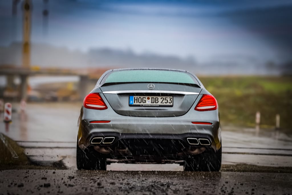 Mercedes-AMG E 63 Heckansicht auf nasser Straße bei Regen