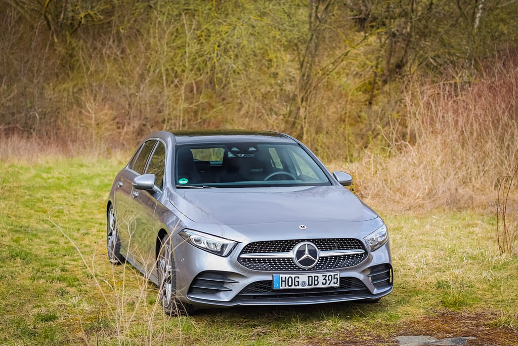 Mercedes-Benz A-Klasse (W177) in grauer Metallic-Lackierung bei einem Automotive-Fotoshooting in einer natürlichen Waldlandschaft mit Front-, Seiten- und Heckansichten.