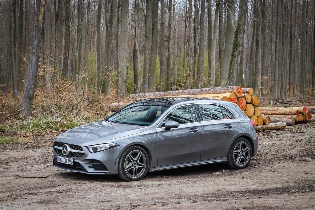Mercedes-Benz A-Klasse (W177) in grauer Metallic-Lackierung bei einem Automotive-Fotoshooting in einer natürlichen Waldlandschaft mit Front-, Seiten- und Heckansichten.
