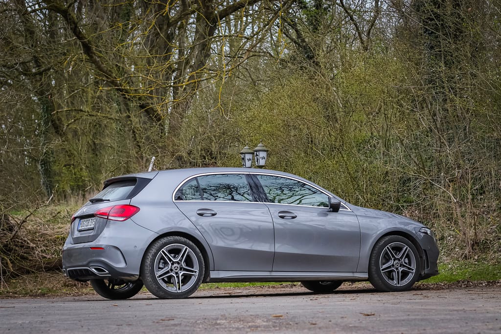 Mercedes-Benz A-Klasse (W177) in grauer Metallic-Lackierung bei einem Automotive-Fotoshooting in einer natürlichen Waldlandschaft mit Front-, Seiten- und Heckansichten.
