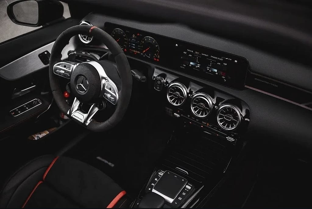 Schwarzer Mercedes-AMG A 45 S (W177) vor industrieller Hafenkulisse mit markantem Panamericana-Grill, roten Bremssätteln und sportlichem Aerodynamikpaket. Hochwertige Automotive Fotografie mit Fokus auf Performance und Design.