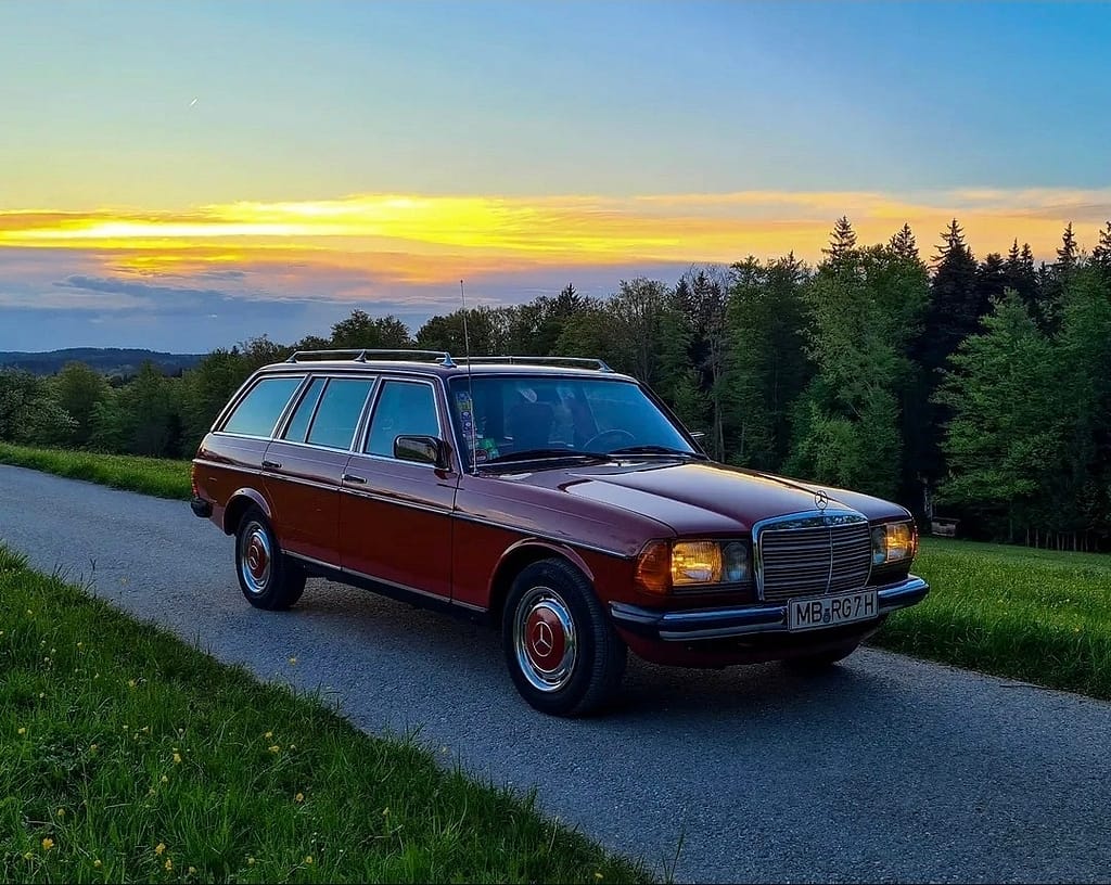 Mercedes-Benz 240 TD S123 in Rot aus der Front-Seitenansicht bei Sonnenuntergang