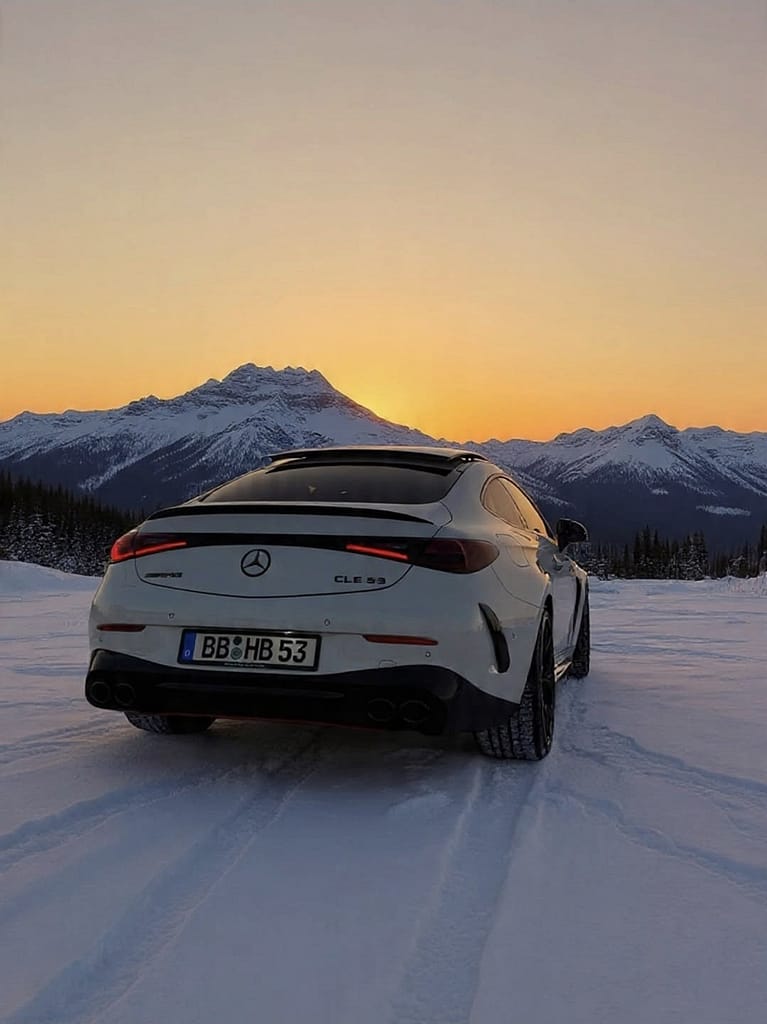 Mercedes-AMG CLE 53 Coupé C236 Heckansicht im Schnee bei Sonnenuntergang vor Alpenpanorama