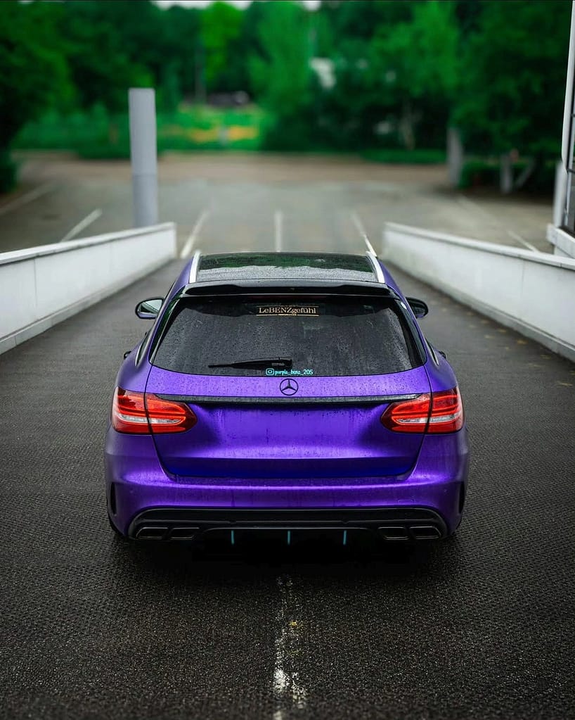 Mercedes-AMG C63 S205 Heckansicht in lila auf nassem Parkdeck