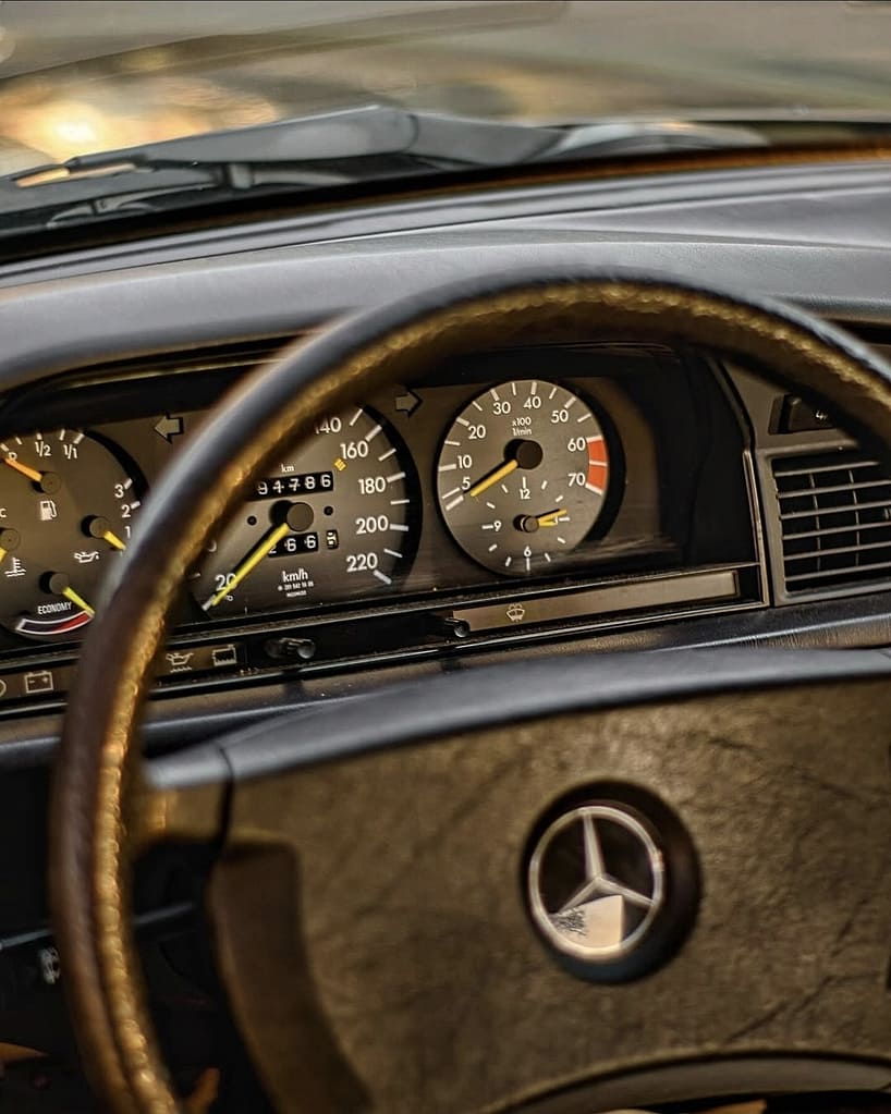 Detailaufnahme des analogen Cockpits und Lenkrads eines klassischen Mercedes-Benz 190E W201
