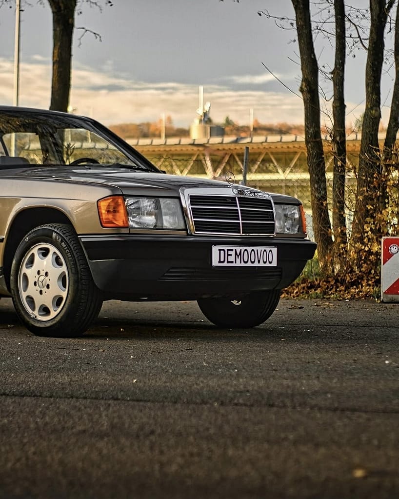 Mercedes-Benz 190E W201 seitliche Frontansicht in natürlicher Outdoor-Kulisse bei Sonnenuntergang