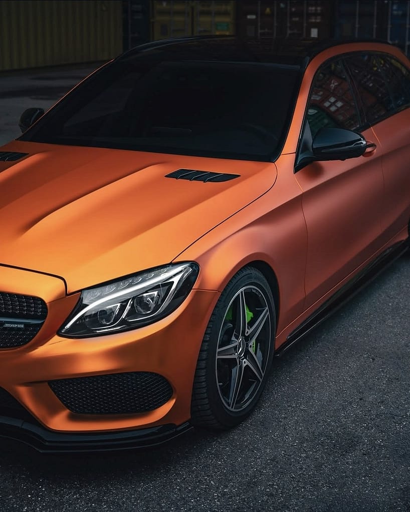 Detailaufnahme der Frontpartie eines orangefarbenen Mercedes-AMG C43 S205 mit AMG Styling und Sportfelgen