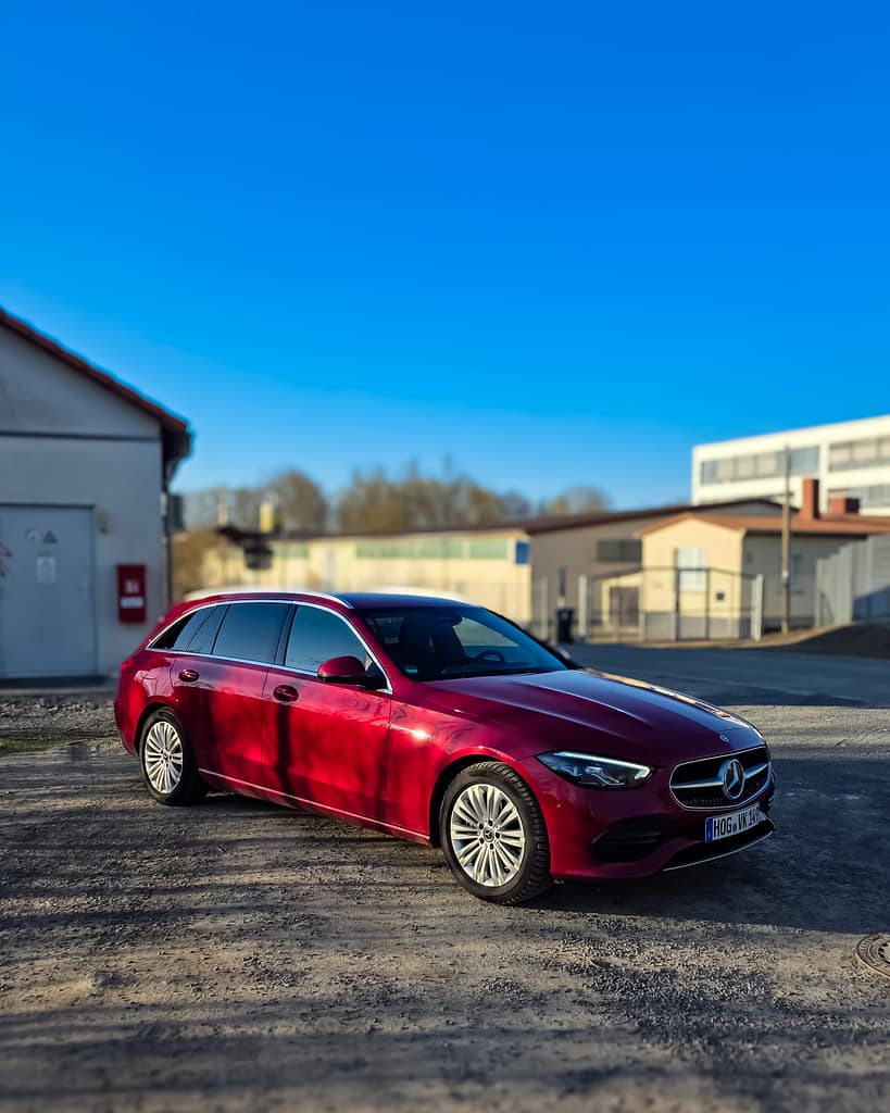 Mercedes-Benz C-Klasse T-Modell rot Front-Seitenansicht auf Industriehof bei Sonnenschein