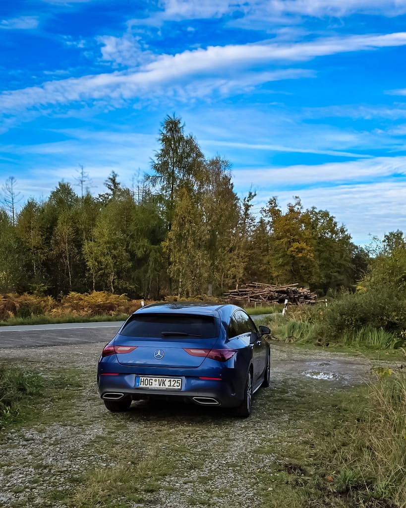 Mercedes-Benz CLA blau heck-Seitenansicht auf Waldweg in natürlicher Landschaft