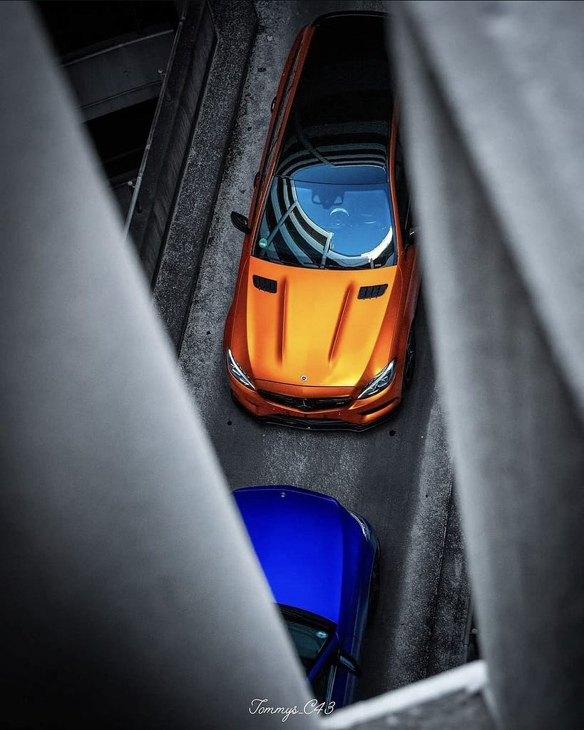 Mercedes-AMG C43 T-Modell S205 in Orange aus der Draufsicht zwischen den Betonstreben eines Parkhauses