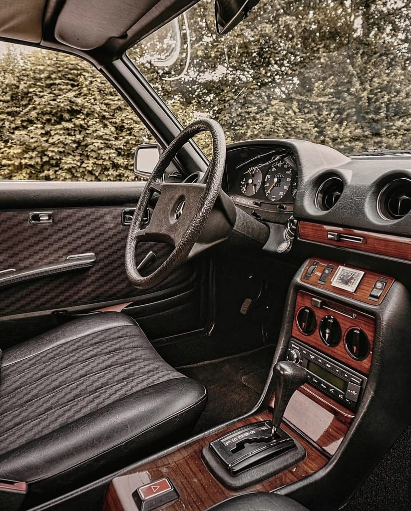 Cockpit des Mercedes-Benz C123 Coupé mit Holzapplikationen, Automatikgetriebe und klassischen Instrumenten.