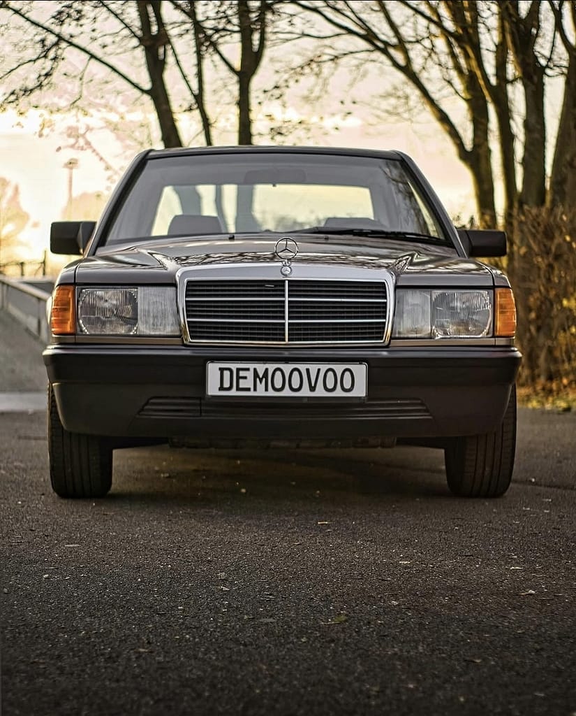 Klassischer Mercedes-Benz 190E W201 Frontansicht mit warmem Abendlicht und urbanem Hintergrund