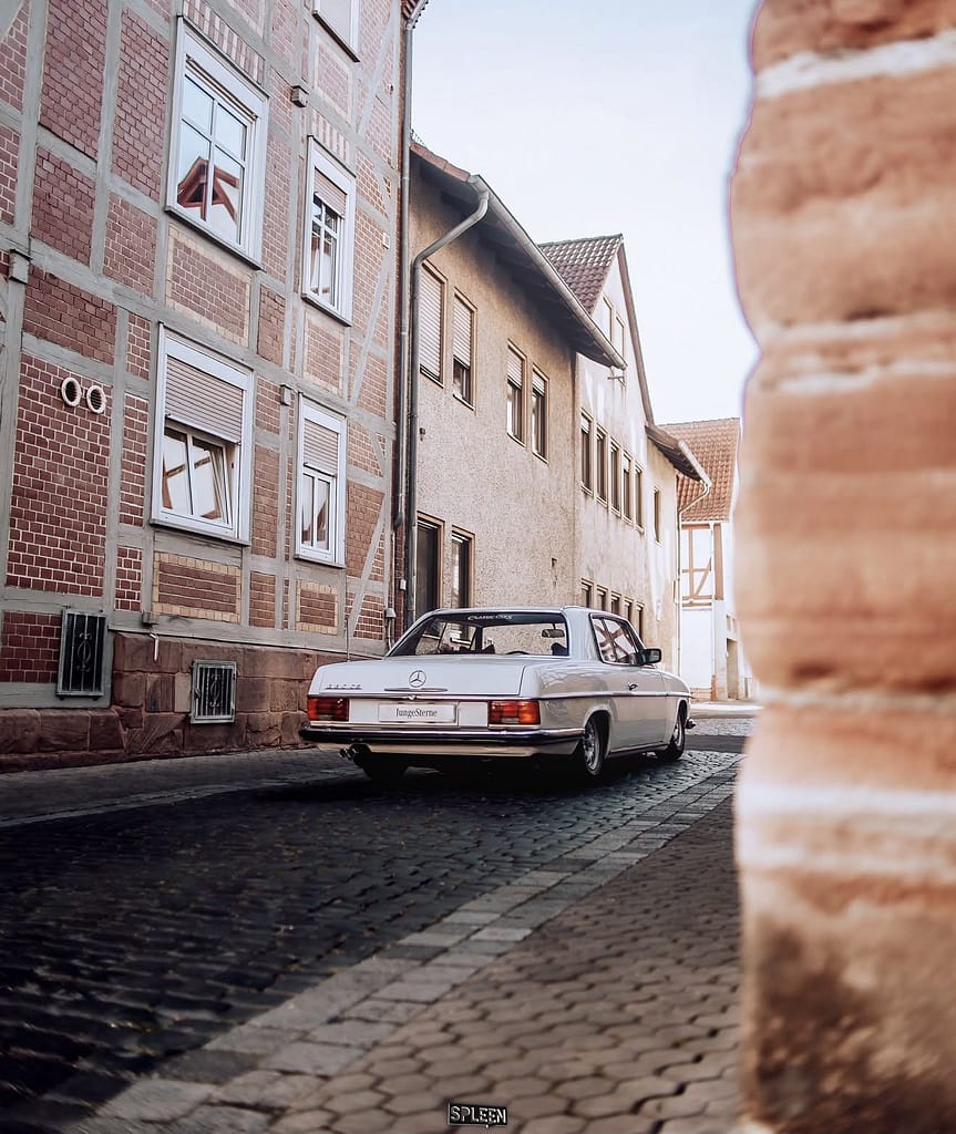 Mercedes-Benz 280 CE (W114) Coupé in Weiß bei einer Automotive-Fotosession auf der Straße, am See und in einer historischen Altstadt – klassische Mercedes-Benz Fotografie auf MB DOME.