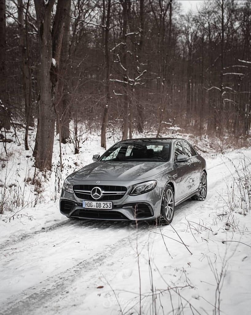 Mercedes-AMG E-Klasse W213 in Silber im verschneiten Wald mit sportlicher Frontansicht