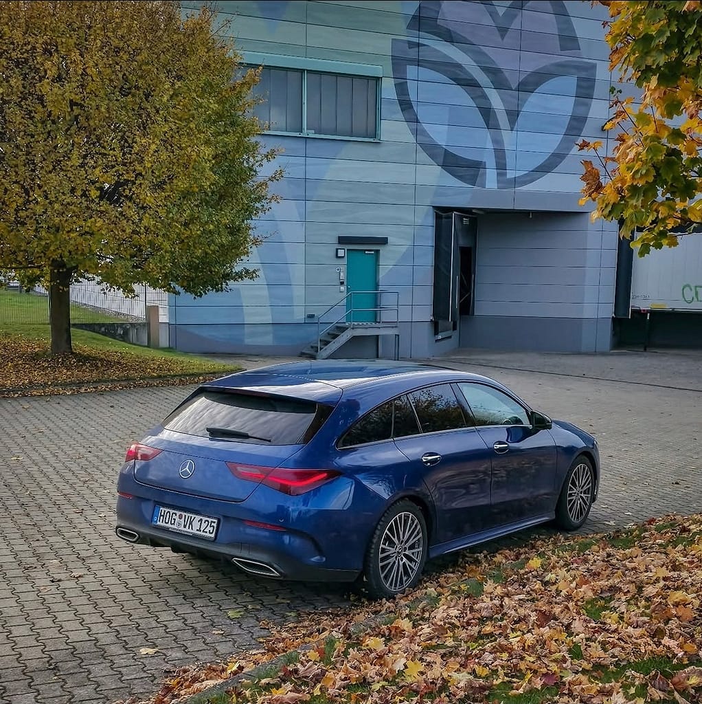 Mercedes-Benz CLA Shooting Brake X118 in Blau auf Parkplatz im Herbst mit gelben Blättern und modernem Design