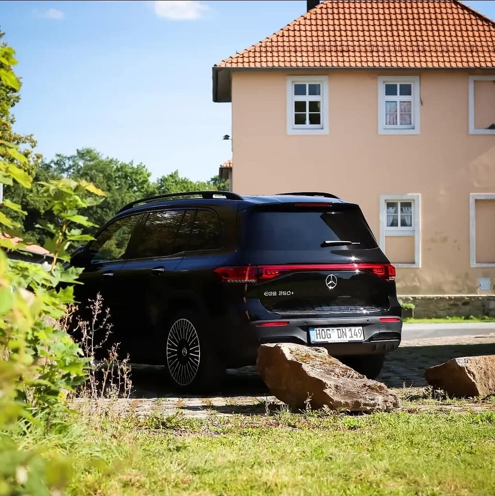 Mercedes-Benz EQB 250+ Elektro SUV Heckansicht vor Haus in ländlicher Umgebung