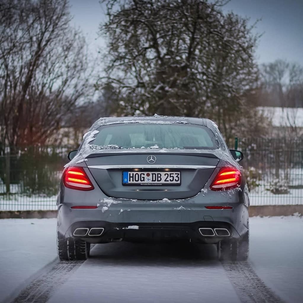 Mercedes-AMG E63 W213 Limousine im Schnee mit Seitenansicht, Front- und Heckansicht in urbaner Industrie-Umgebung