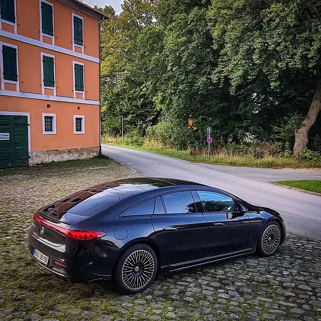 Mercedes-Benz EQS 450 Plus in Schwarz als Elektro Luxuslimousine aus verschiedenen Perspektiven auf Straße und Parkplatz