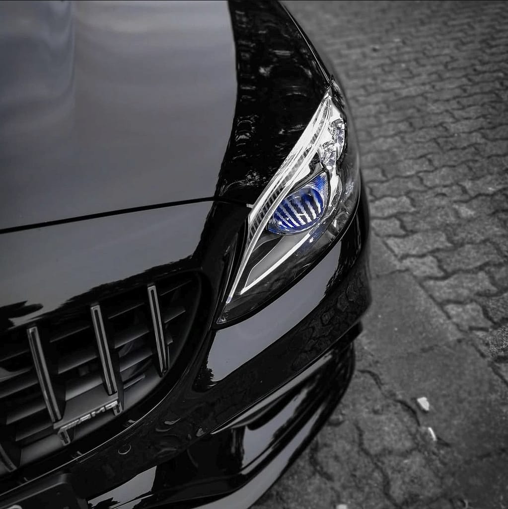 Mercedes-AMG C63 W205 in Schwarz mit V8 Biturbo Motor auf Landstraße bei dramatischem Himmel und Detailaufnahmen von AMG Design und Performance Komponenten
