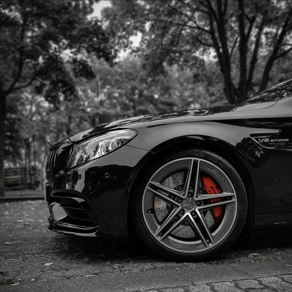 Mercedes-AMG C63 W205 in Schwarz mit V8 Biturbo Motor auf Landstraße bei dramatischem Himmel und Detailaufnahmen von AMG Design und Performance Komponenten