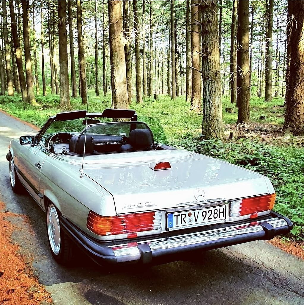 Mercedes-Benz 560 SL R107 Cabrio mit V8 Motor in klassischem Design auf Landstraße und Naturkulisse fotografiert