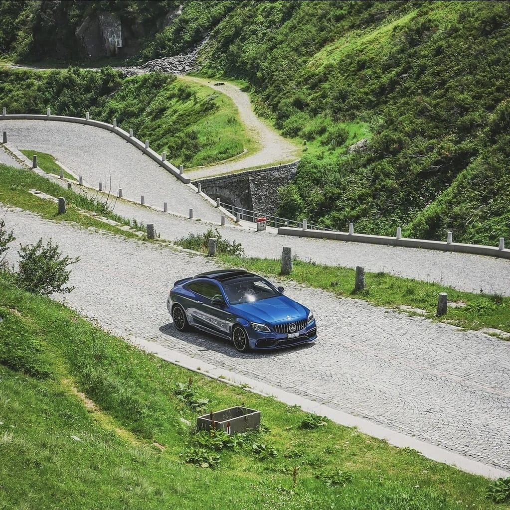 Mercedes-AMG C63 S auf kurviger Passstraße mit Bergpanorama