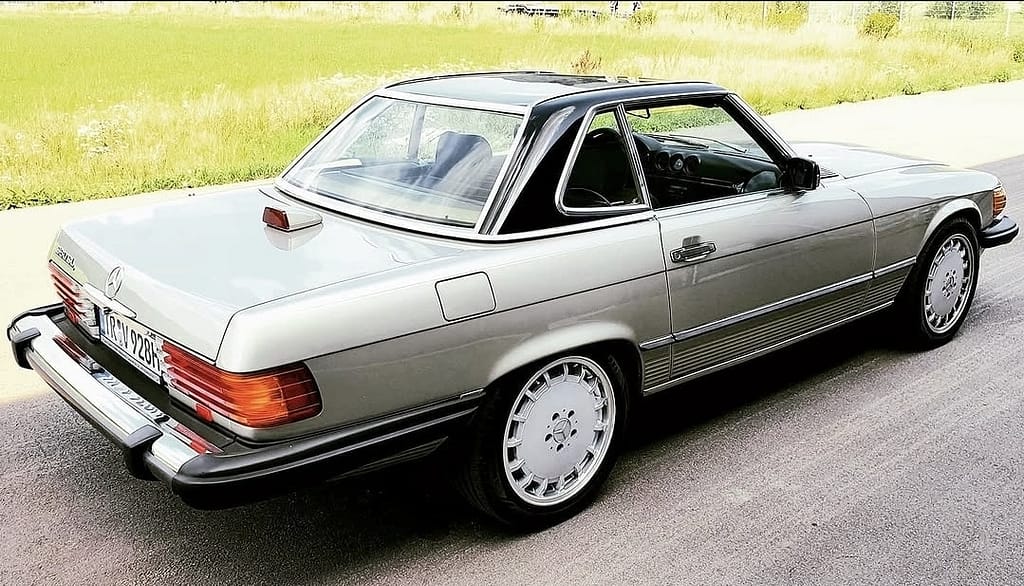 Mercedes-Benz 560 SL R107 Cabrio mit V8 Motor in klassischem Design auf Landstraße und Naturkulisse fotografiert