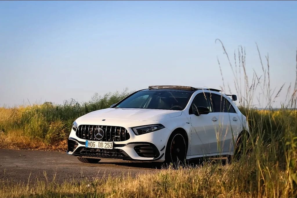 Mercedes-AMG A 45 S weiß Front-Seitenansicht auf Landstraße im Sommer