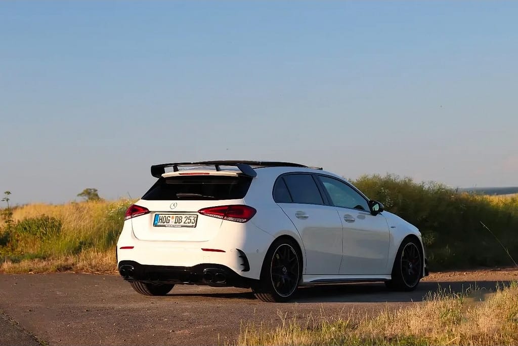 Mercedes-AMG A 45 S weiß Heck-Seitenansicht auf Landstraße im Abendlicht