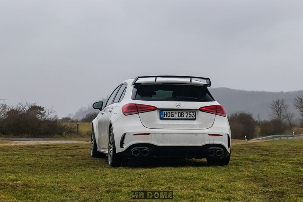 Mercedes-AMG A45 S 4MATIC+ Heckansicht auf Wiese mit Heckspoiler