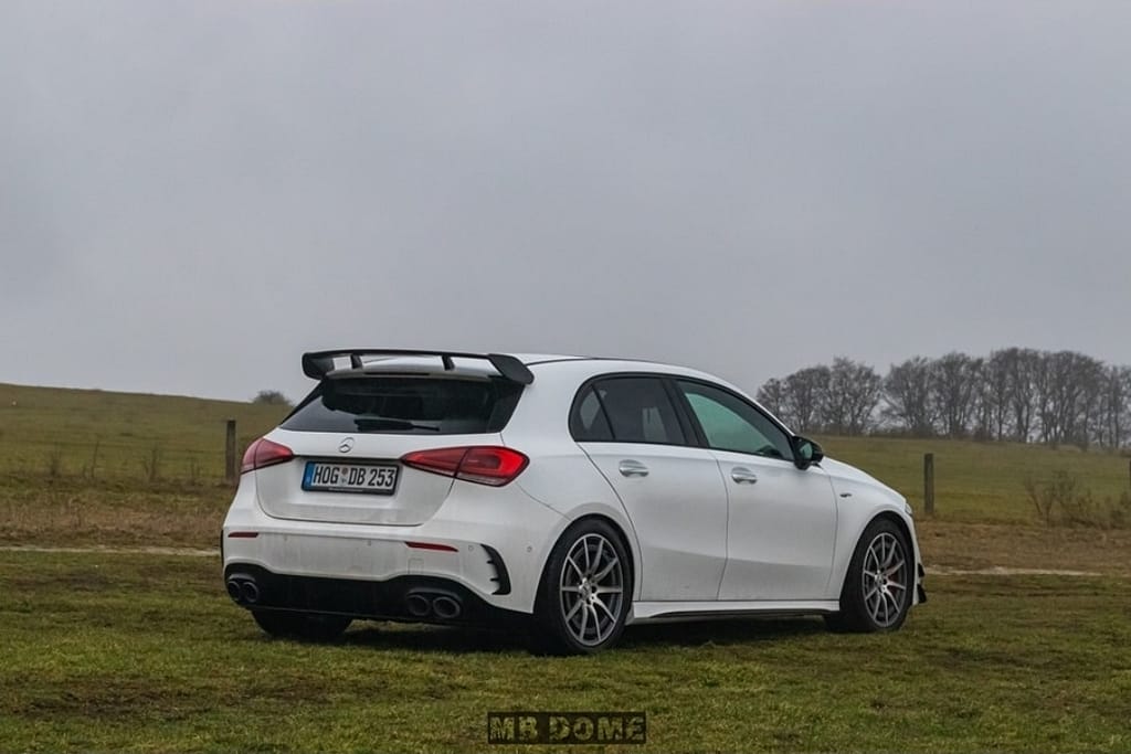 Mercedes-AMG A45 S 4MATIC+ weiß Heck Seitenansicht auf Wiese