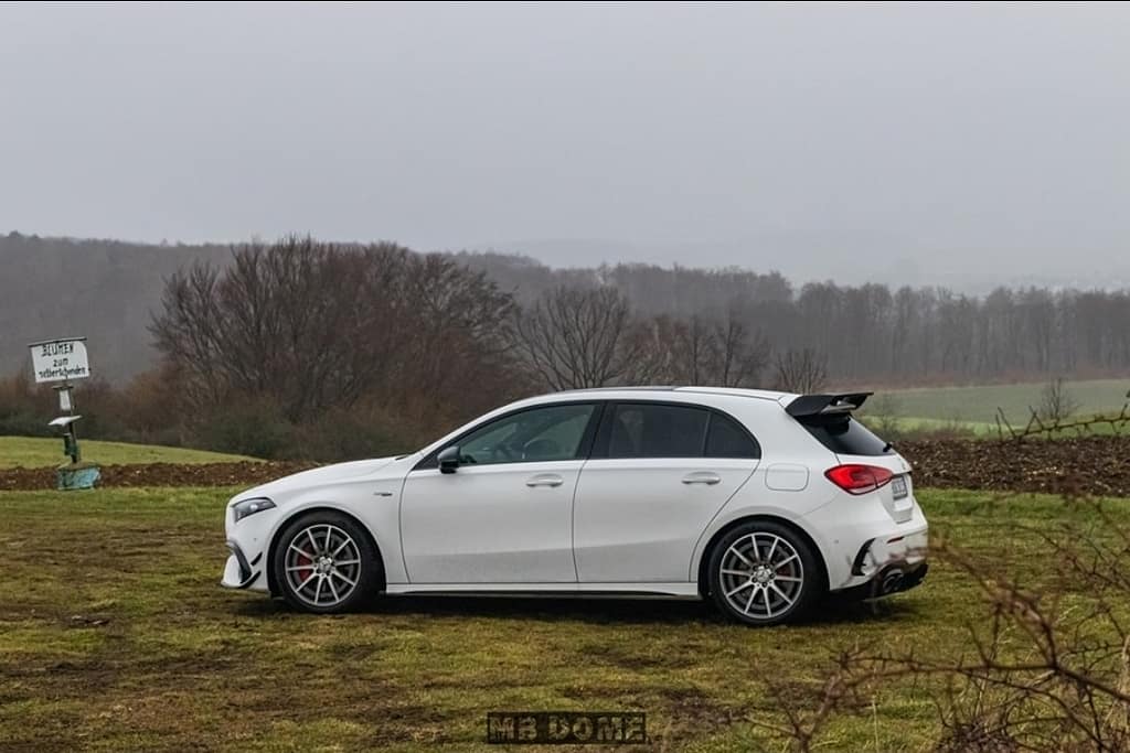 Mercedes-AMG A45 S 4MATIC+ weiß Seitenansicht auf Wiese in ländlicher Landschaft