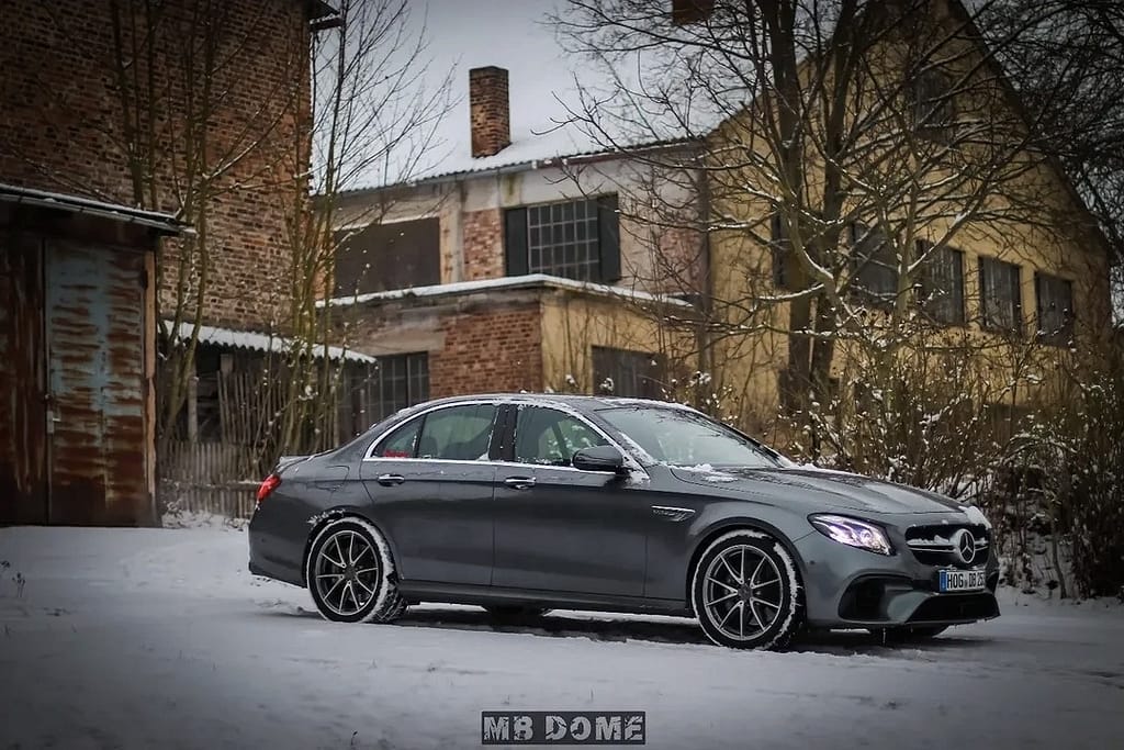 Mercedes-AMG E63 W213 Limousine im Schnee mit Seitenansicht, Front- und Heckansicht in urbaner Industrie-Umgebung
