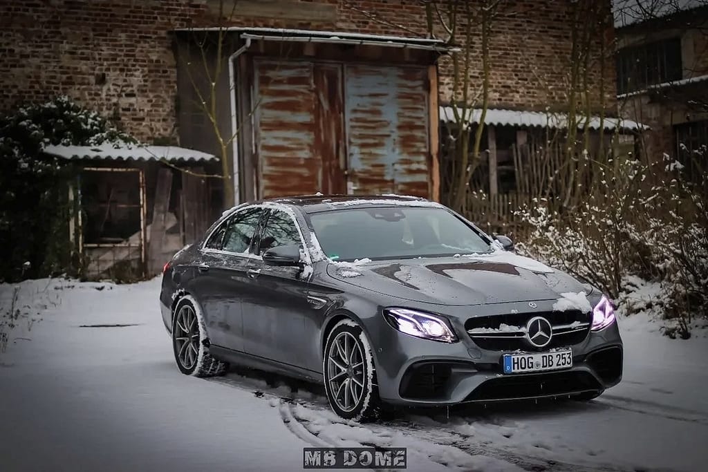 Mercedes-AMG E63 W213 Limousine im Schnee mit Seitenansicht, Front- und Heckansicht in urbaner Industrie-Umgebung