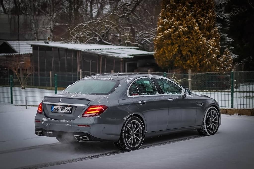 Mercedes-AMG E63 W213 Limousine im Schnee mit Seitenansicht, Front- und Heckansicht in urbaner Industrie-Umgebung
