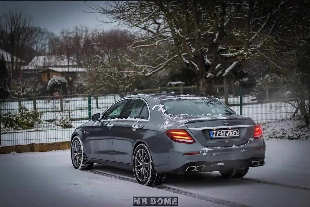 Mercedes-AMG E63 W213 Limousine im Schnee mit Seitenansicht, Front- und Heckansicht in urbaner Industrie-Umgebung