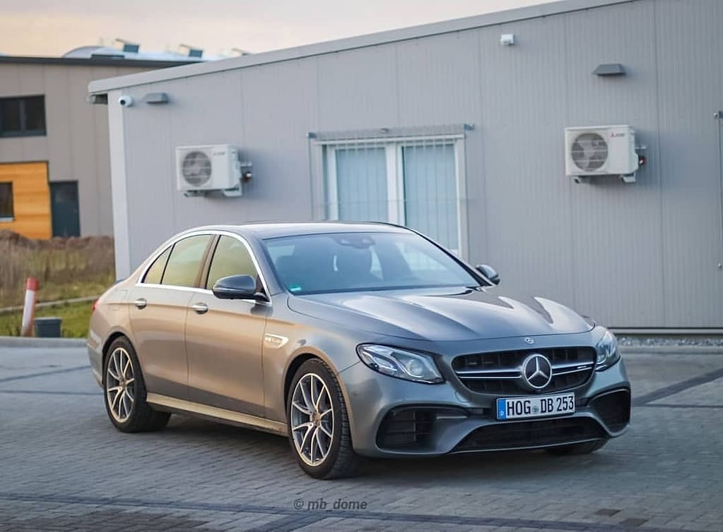 Mercedes-AMG E63 in Front-Seitenansicht vor einem modernen Industriegebäude im warmen Abendlicht fotografiert