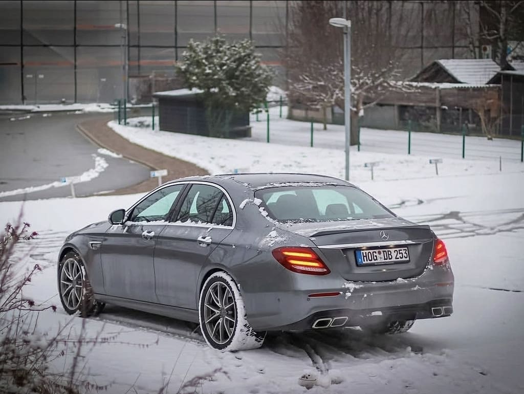 Mercedes-AMG E63 W213 Limousine im Schnee mit Seitenansicht, Front- und Heckansicht in urbaner Industrie-Umgebung