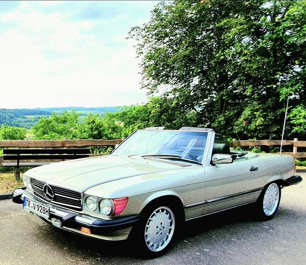 Mercedes-Benz 560 SL R107 Cabrio mit V8 Motor in klassischem Design auf Landstraße und Naturkulisse fotografiert