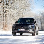 Mercedes-Benz EQB Front-Seitenansicht auf verschneiter Waldstraße im Winter