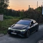 Mercedes-Benz EQS in Schwarz mit LED-Lichtsignatur bei Dämmerung auf einer Straße fotografiert