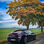 Mercedes-Benz EQS 450+ Heckansicht auf Landstraße unter Herbstbaum