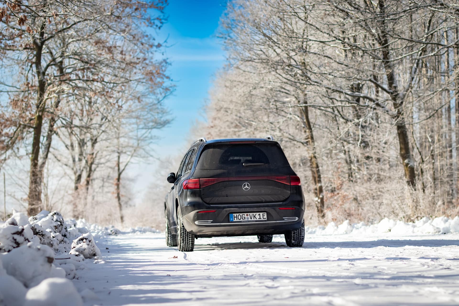 Mercedes-Benz EQB auf verschneitem Waldweg im Winter