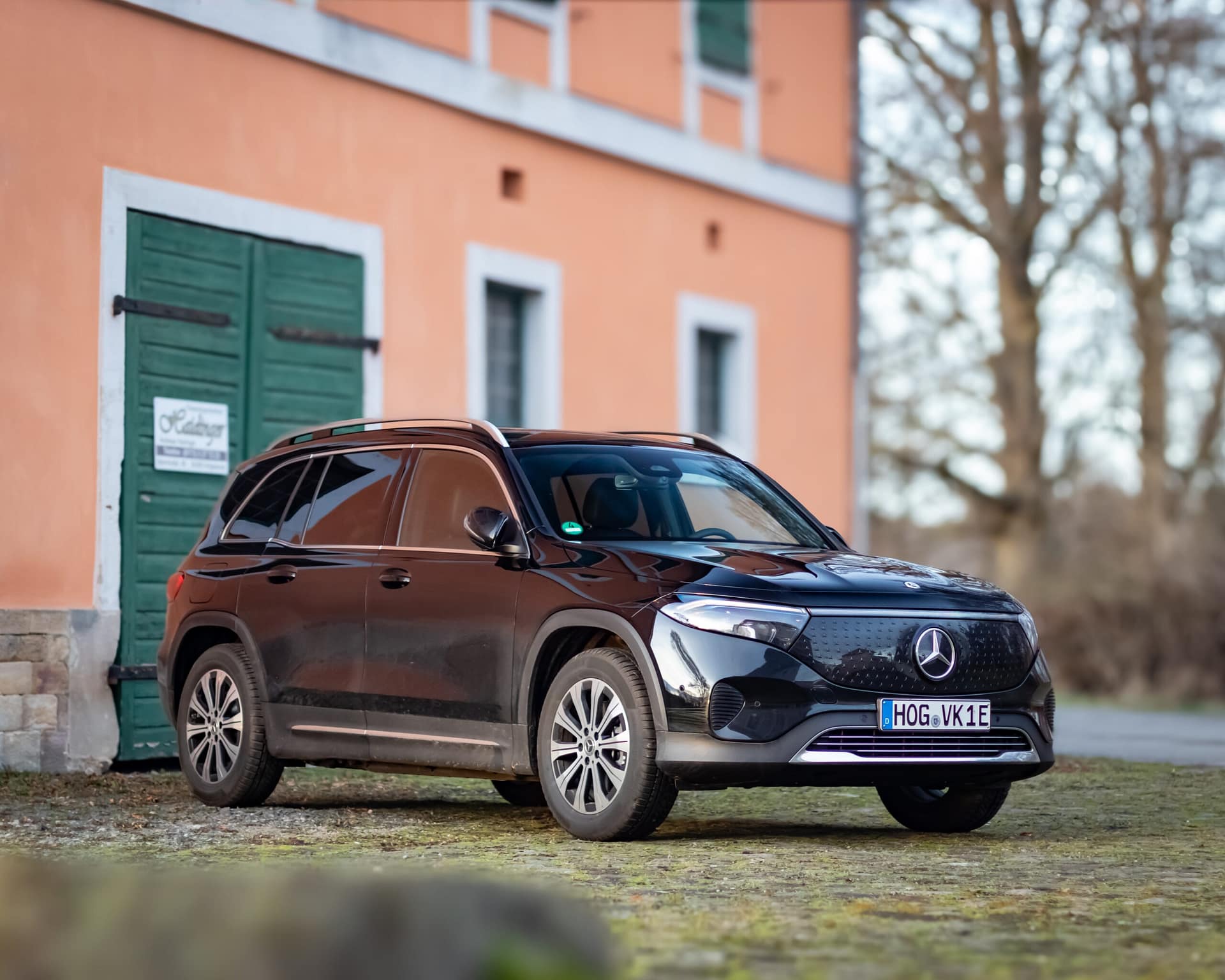 Mercedes-Benz EQB Elektro SUV Frontansicht vor Gebäude mit orangefarbener Fassade