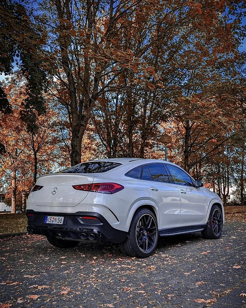 Mercedes-AMG GLE 53 Coupé C167 in Weiß mit schwarzem AMG Styling und sportlicher Heckansicht im herbstlichen Park bei Sonnenuntergang